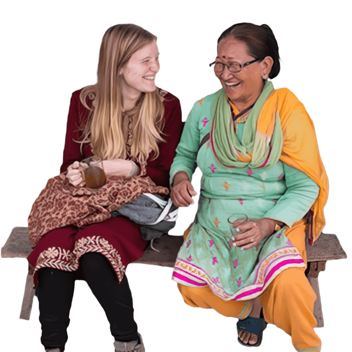 Missionary and her local friend dressed up in traditional clothe, having a cup of tea