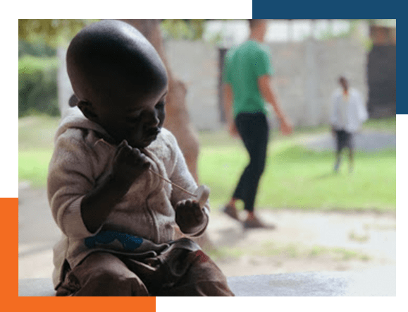 Small African child in forground as others play in the background.