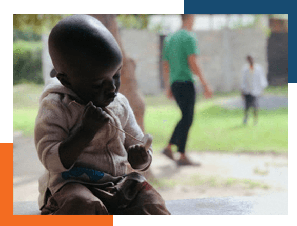 Small African child in forground as others play in the background.